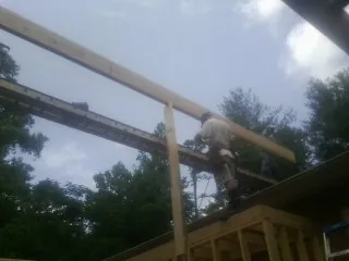 Carpenter setting a ridge beam over a new addition frame — Ice Dam Removal by Roofing Brothers in Sussex