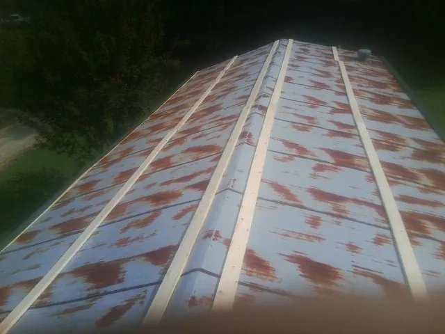 Rusted metal roof panels with new wood purlins before replacement — Storm Damage Roof Repair in Sussex by Roofing Brothers